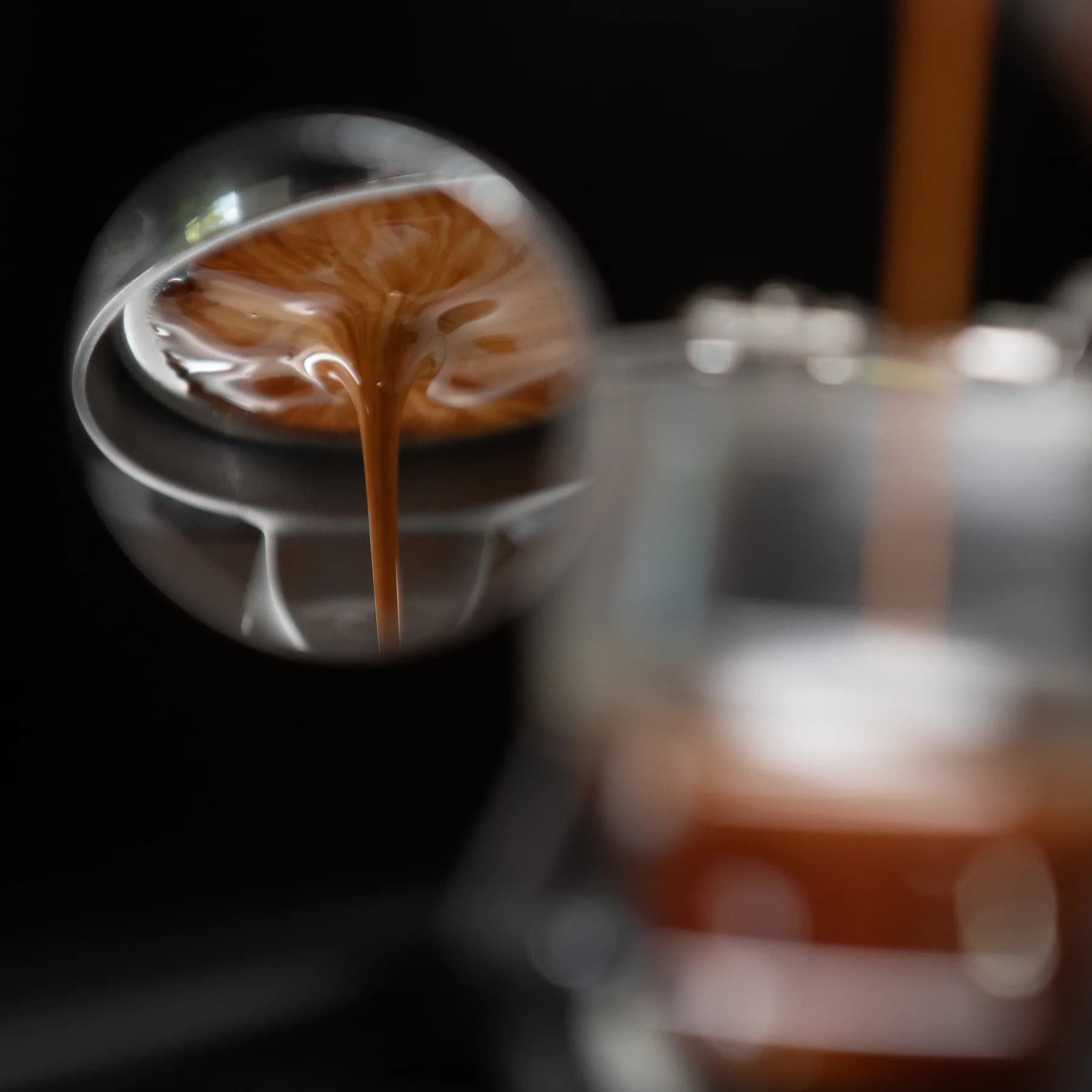 Espresso extrayéndose de un portafiltro sin fondo en una cafetera Flair