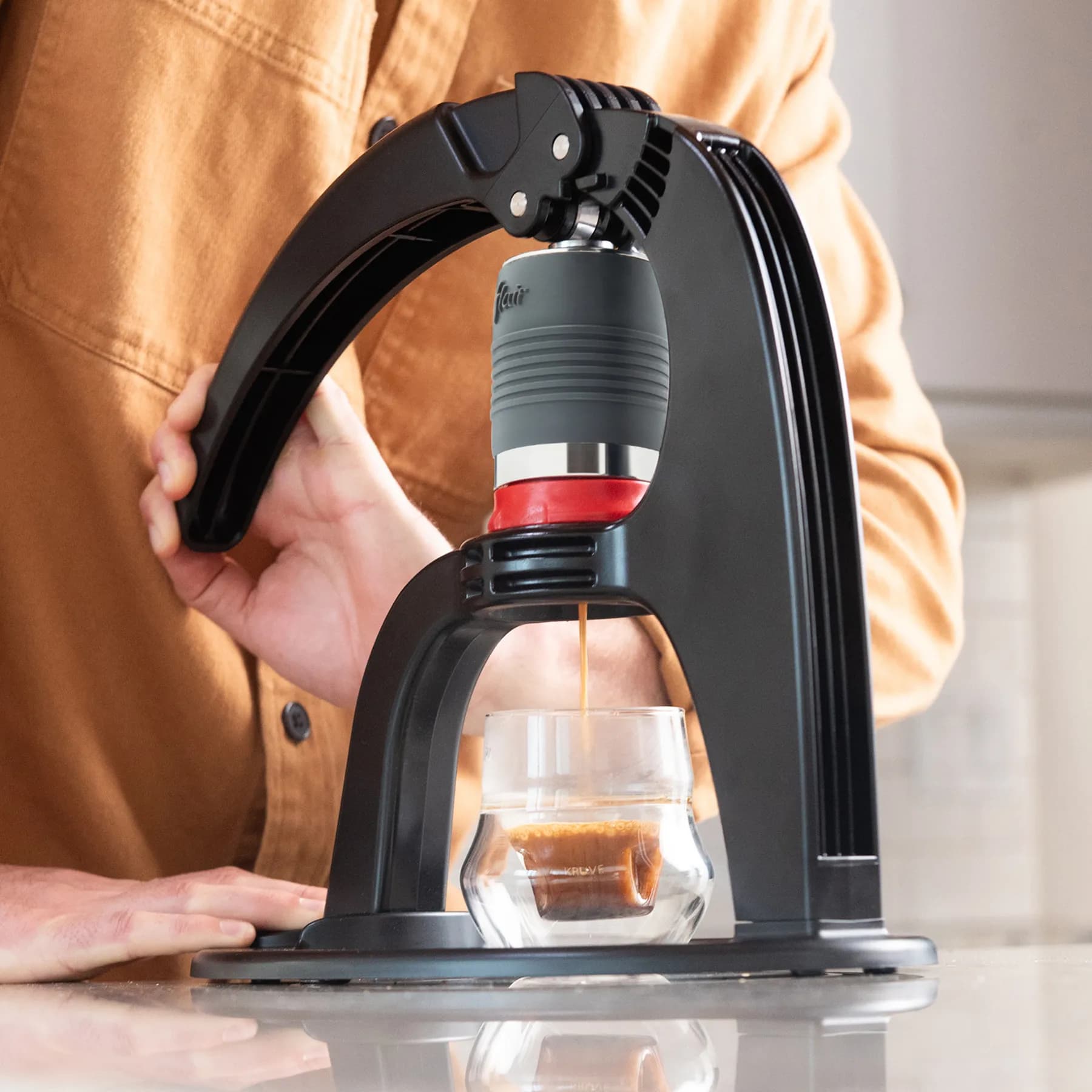 Persona preparando espresso con una cafetera manual Flair